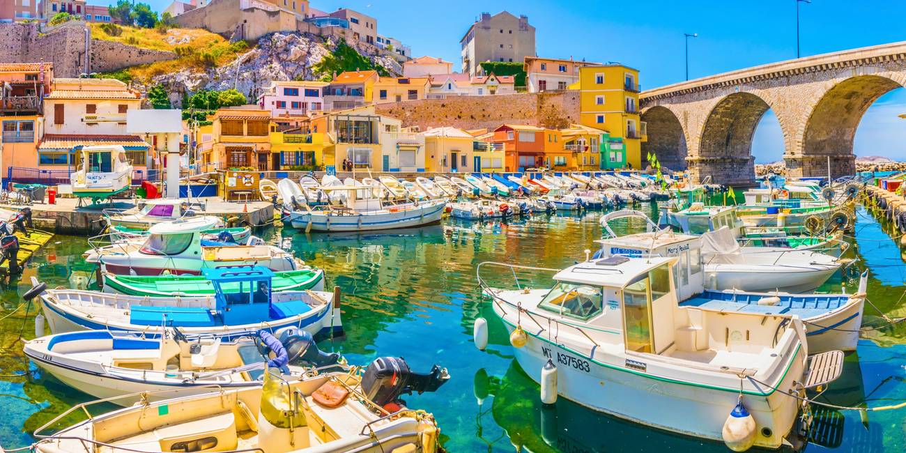 Admire the picturesque charm of the Vallon des Auffes in Marseille, with its colorful fishing boats, seaside cabins, and authentic Mediterranean atmosphere – Marseille Pass.